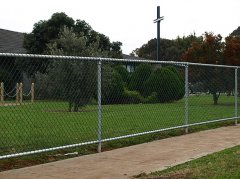 The chain link fencing is a safety fence for the basketball court